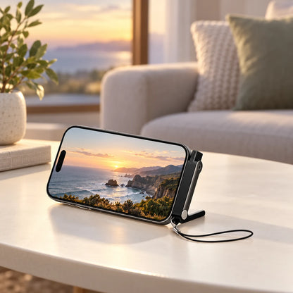 Black FlexDock supporting a landscape phone showing a coastal video on a living-room table.